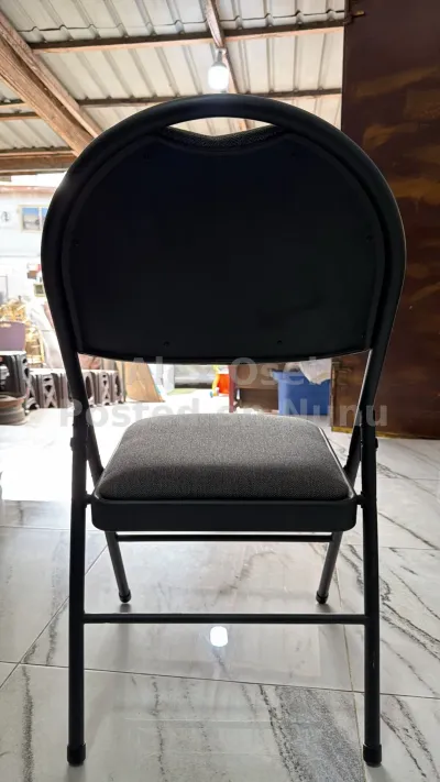black padded folding chair with a tubular metal frame.